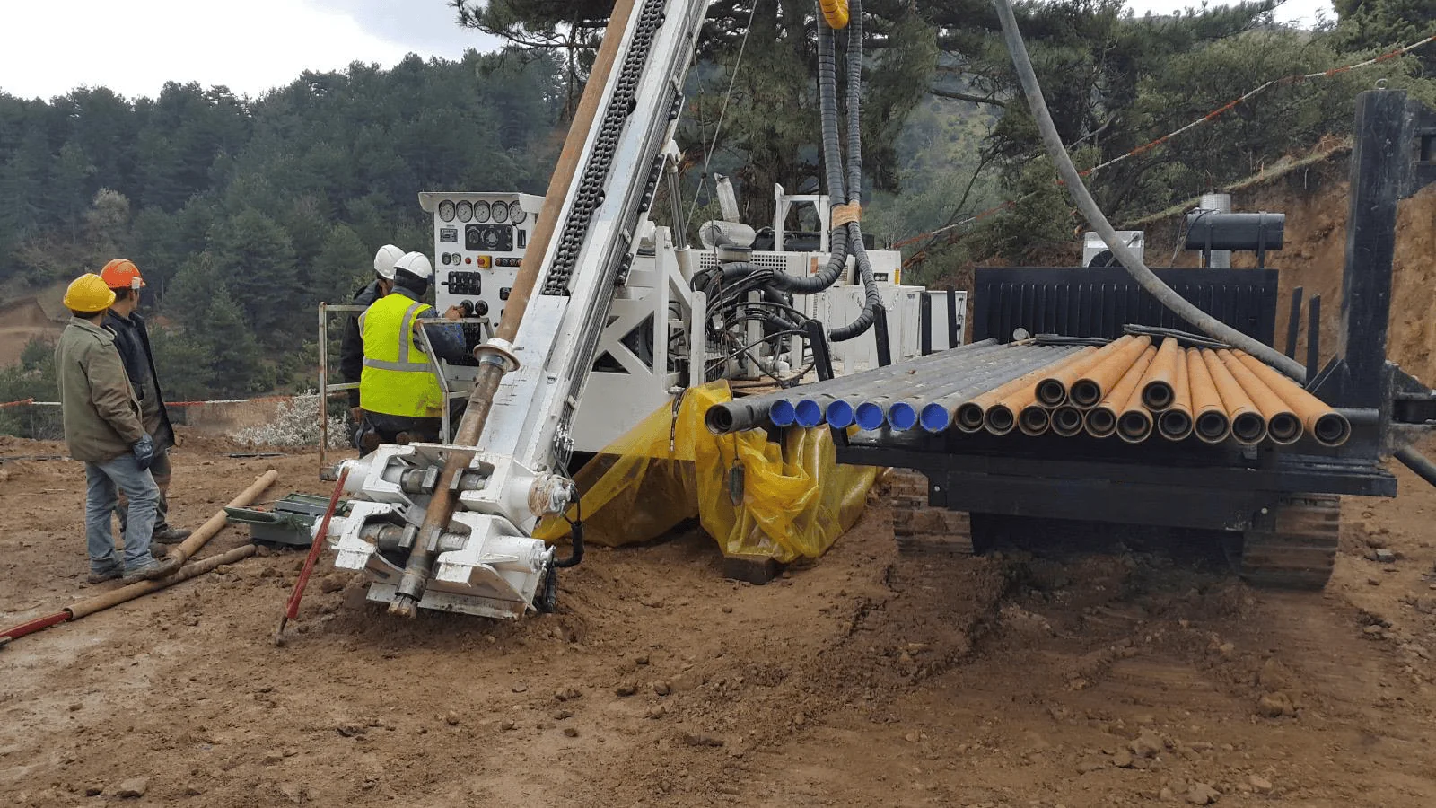 Field drilling crew operating a tracked exploration rig
